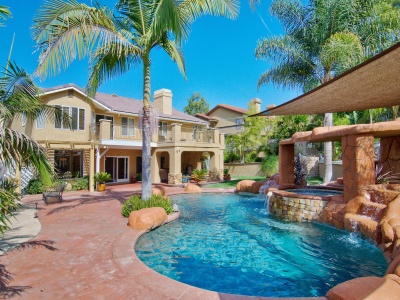 swimming pool with a waterfall feature and jacuzzi