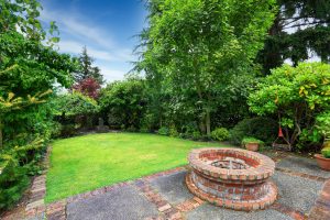 a green backyard with fire pits installed 