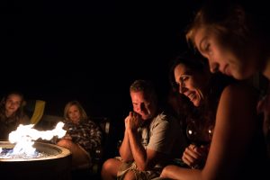 friends gathered around a fire put