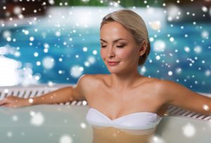 woman sitting in a pool as snow falls