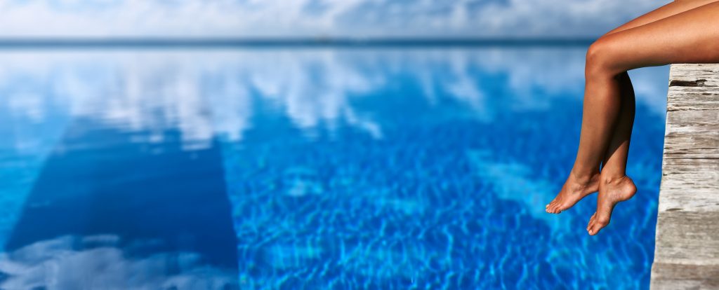 woman with legs lingering over pools