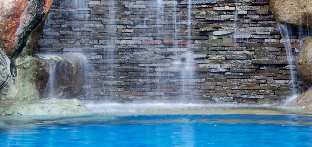 a home with a backyard pool and waterfall