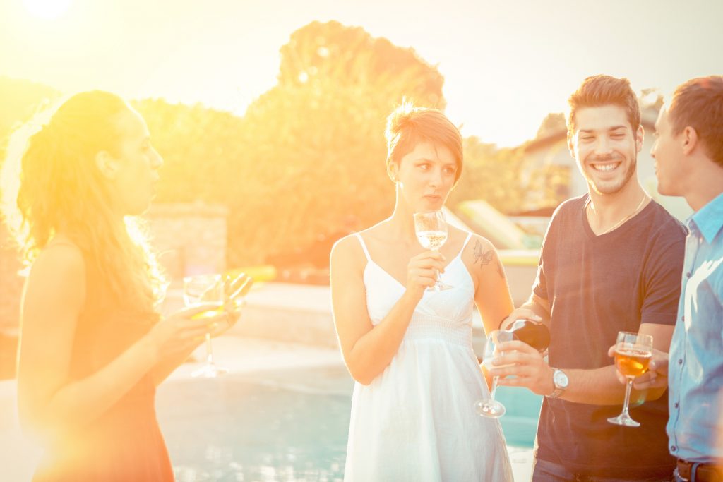 a couple of friends hanging out having poolside conversations outside