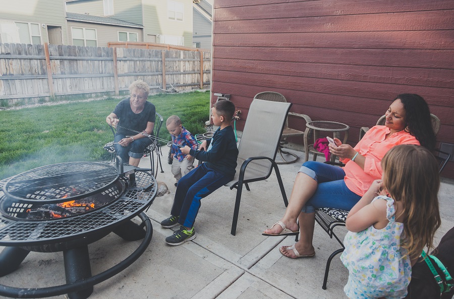 Family enjoying the outdoors cooking marshmallows over fire.